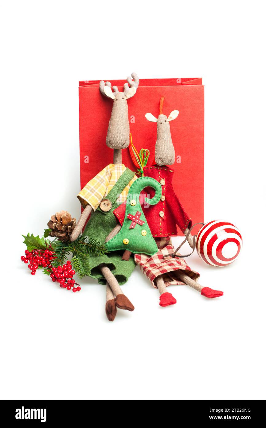 Weihnachtsgeschenk Geschenk. Weihnachten traditionelles handgemachtes Nähen weicher Textilspielzeug Elch in rotem und grünem Kleid auf weißem Hintergrund Stockfoto