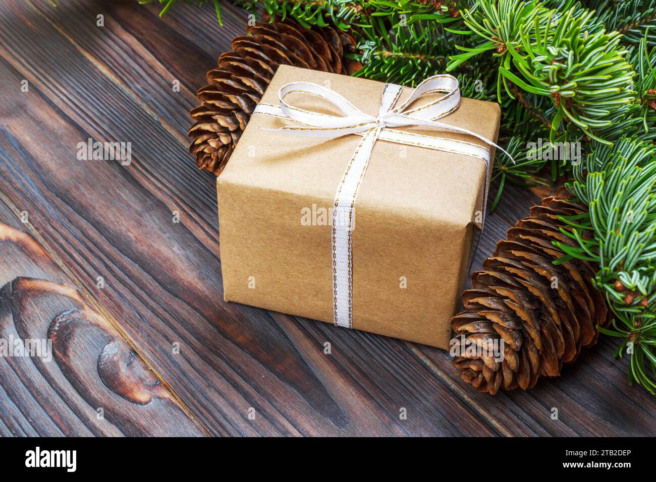 Weihnachten Komposition. Weihnachten Geschenk, gestrickte Decke, Tannenzapfen, tannenzweigen auf hölzernen weißen Hintergrund. Flach, Ansicht von oben. Stockfoto