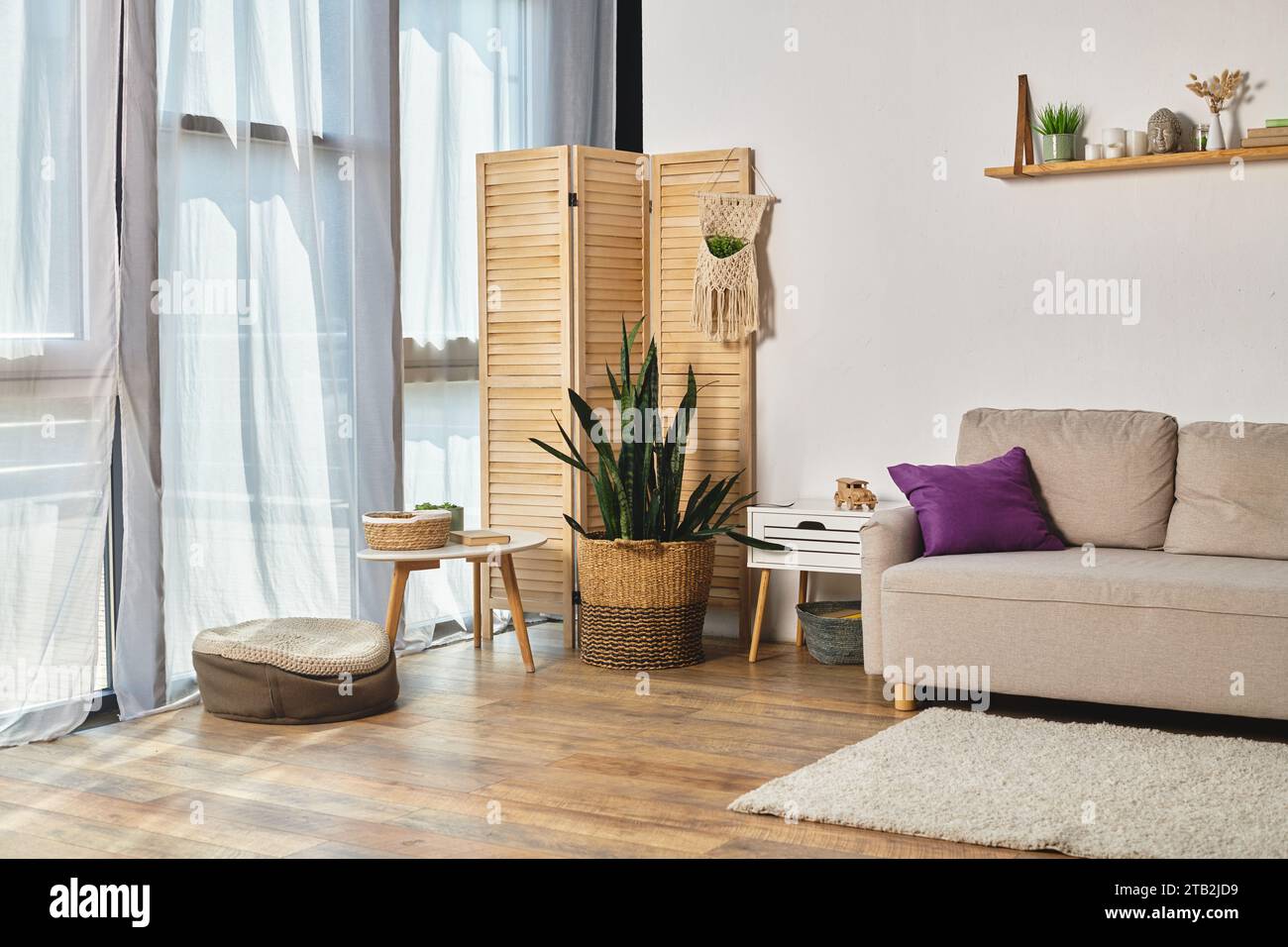 Apartment mit geräumigem Wohnzimmer mit modernen Möbeln, großen Fenstern und grünen Topfpflanzen Stockfoto