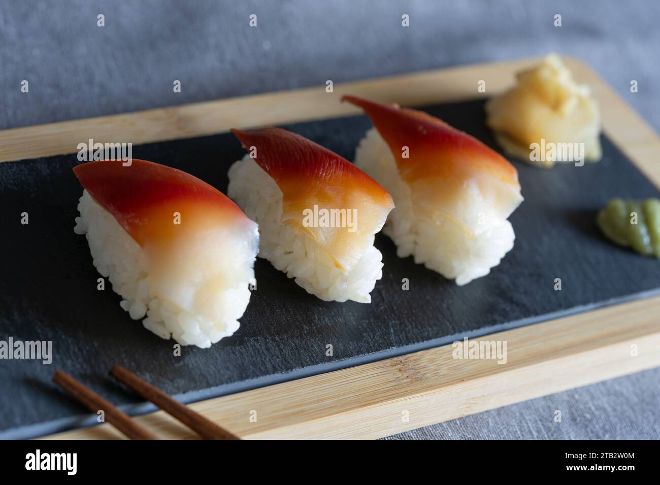Stücke hausgemachter Surf-Muschel-Sushi (essbare Salzwassermuschel, Japanisch: Hokki gai): Japanische Gerichte, die als Snack auf einem Schieferbrett gegessen werden Stockfoto