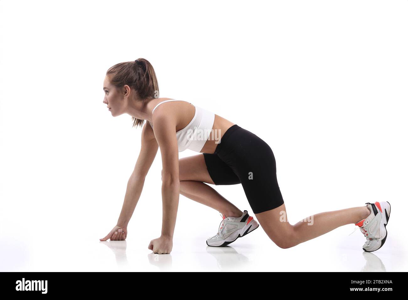 Attraktiv sitzende Frau, die im Studio mit Copyspace trainiert. Bild einer gesunden jungen Athletin, die Fitness-Workout vor weißem Hintergrund macht. Stockfoto