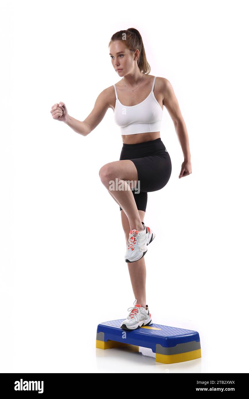 Attraktiv sitzende Frau, die im Studio mit Copyspace trainiert. Bild einer gesunden jungen Athletin, die Fitness-Workout vor weißem Hintergrund macht. Stockfoto