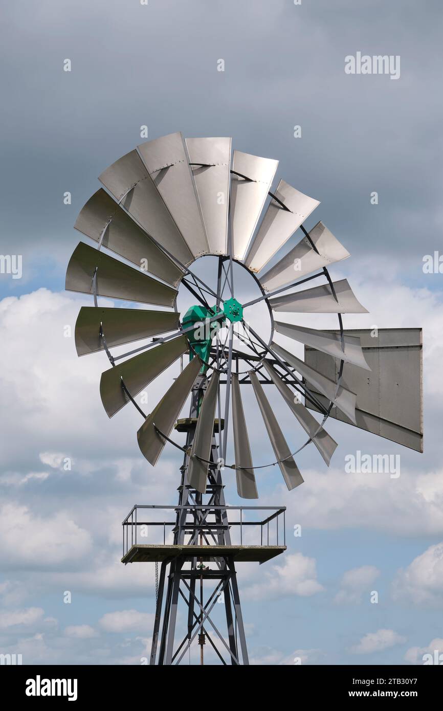 Die Metallblätter einer amerikanischen Windmaschine gegen einen bewölkten und stürmischen Himmel. Stockfoto