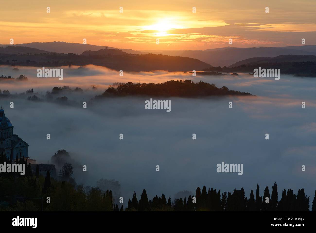 Luftlandschaft mit niedrigen Morgenwolken Feuchtigkeit füllen grüne Tal in der toskanischen Landschaft, in hellen Morgenlicht von Montepulciano, Sien aufgenommen Stockfoto