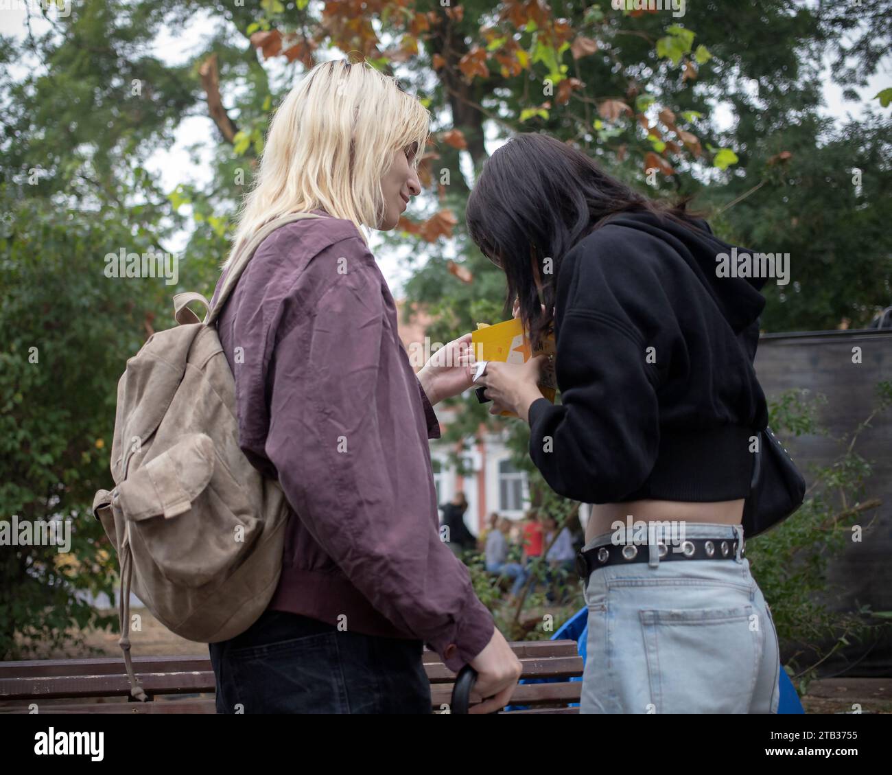 Belgrad, Serbien, 24. September 2023: Zwei junge Frauen teilen sich einen Snack auf der Straße Stockfoto