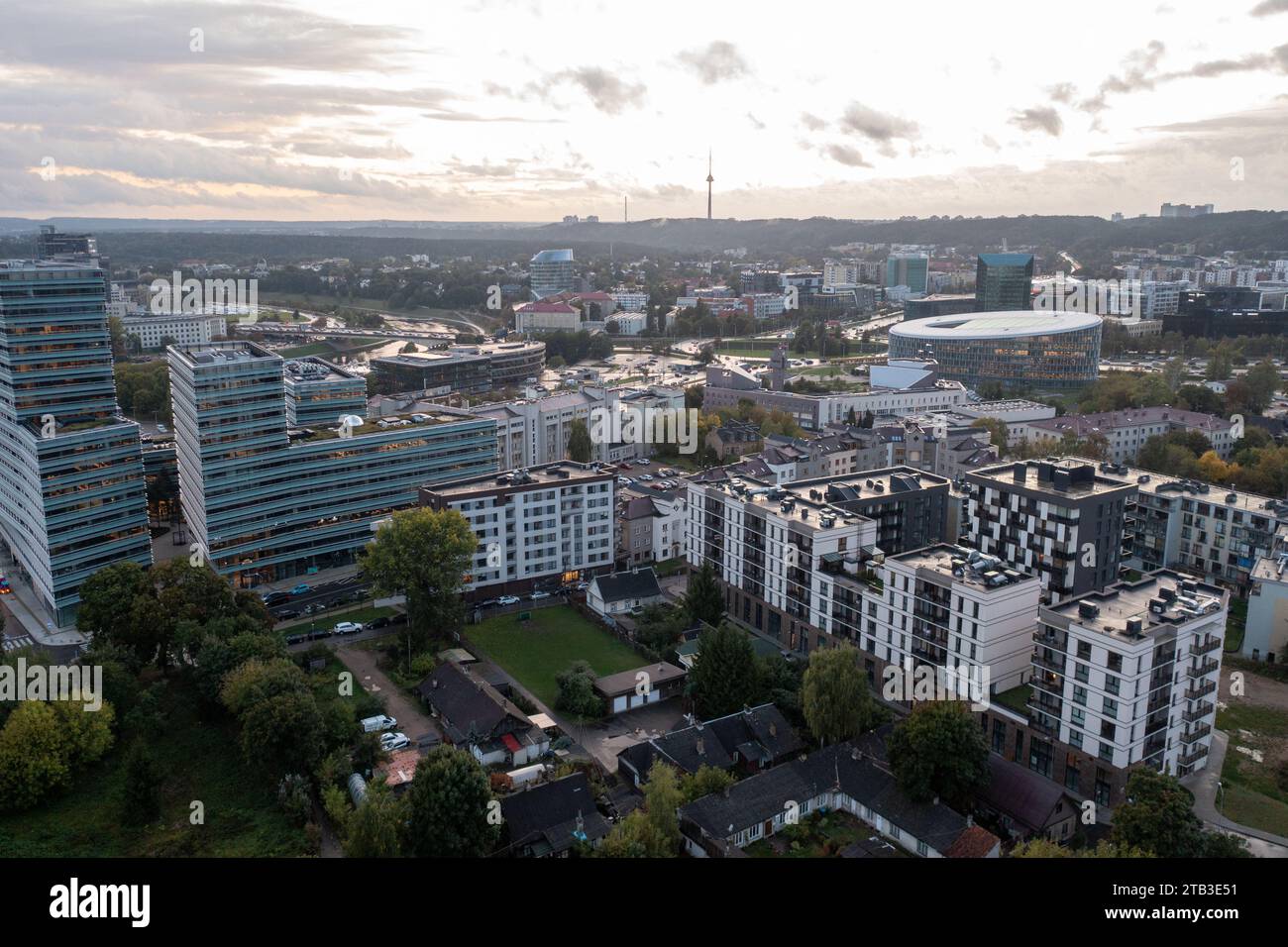 Drohnenfotografie von alten und neuen mehrstöckigen Apartmentkomplexen mit Bäumen und viel Grün während des bewölkten Sommers. Stockfoto