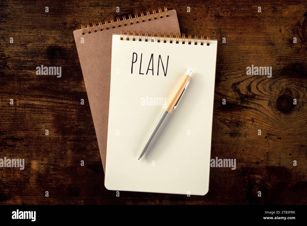 Planen. Notizbuch mit Stift, oben flach auf einem rustikalen Holztisch Stockfoto