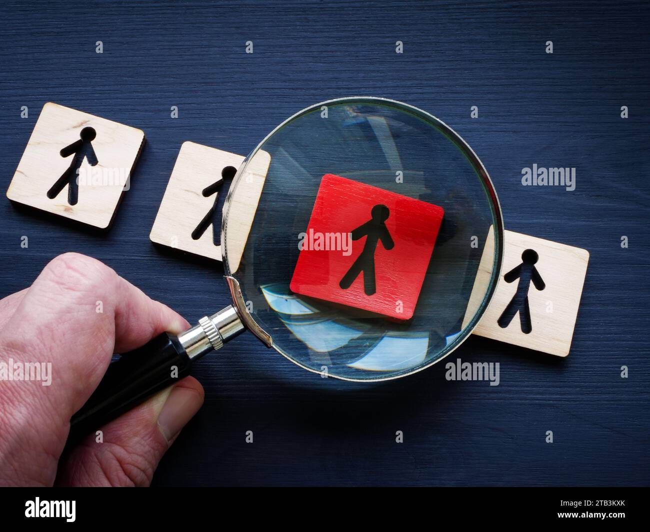 Talentgewinnung und -Management. Hand mit Lupe und Figuren. Stockfoto