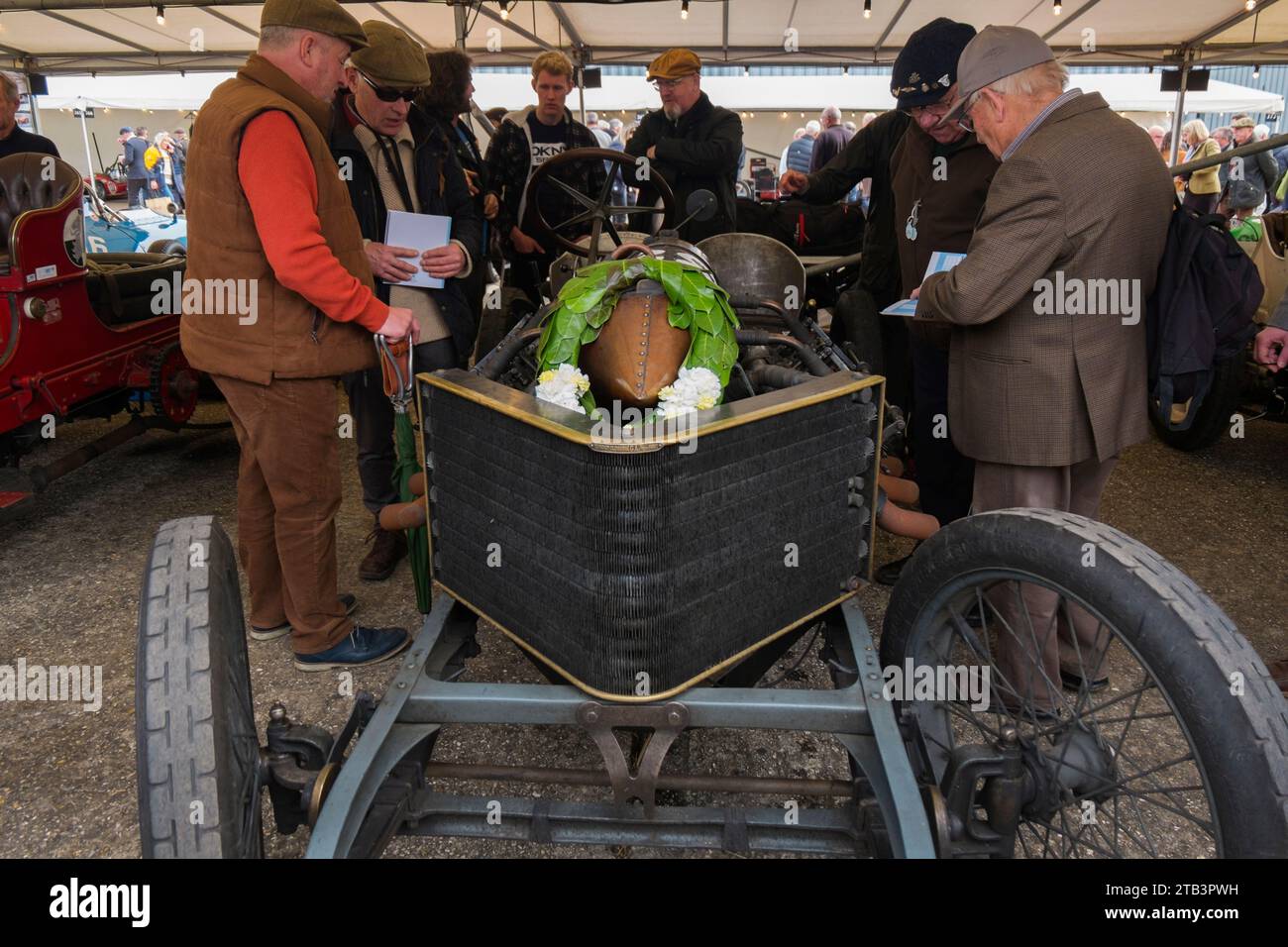 Männer im Gespräch neben dem 1905 Darracq 200 PS von Mark Walker auf der 80. Mitgliederversammlung, Goodwood Motor Racing Circuit, Chichester, Großbritannien Stockfoto