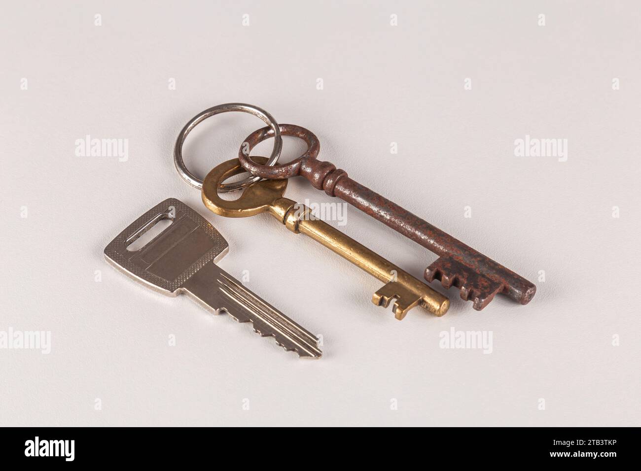 Zwei Vintage- und ein neuer Schlüssel auf weißem Hintergrund. Stockfoto