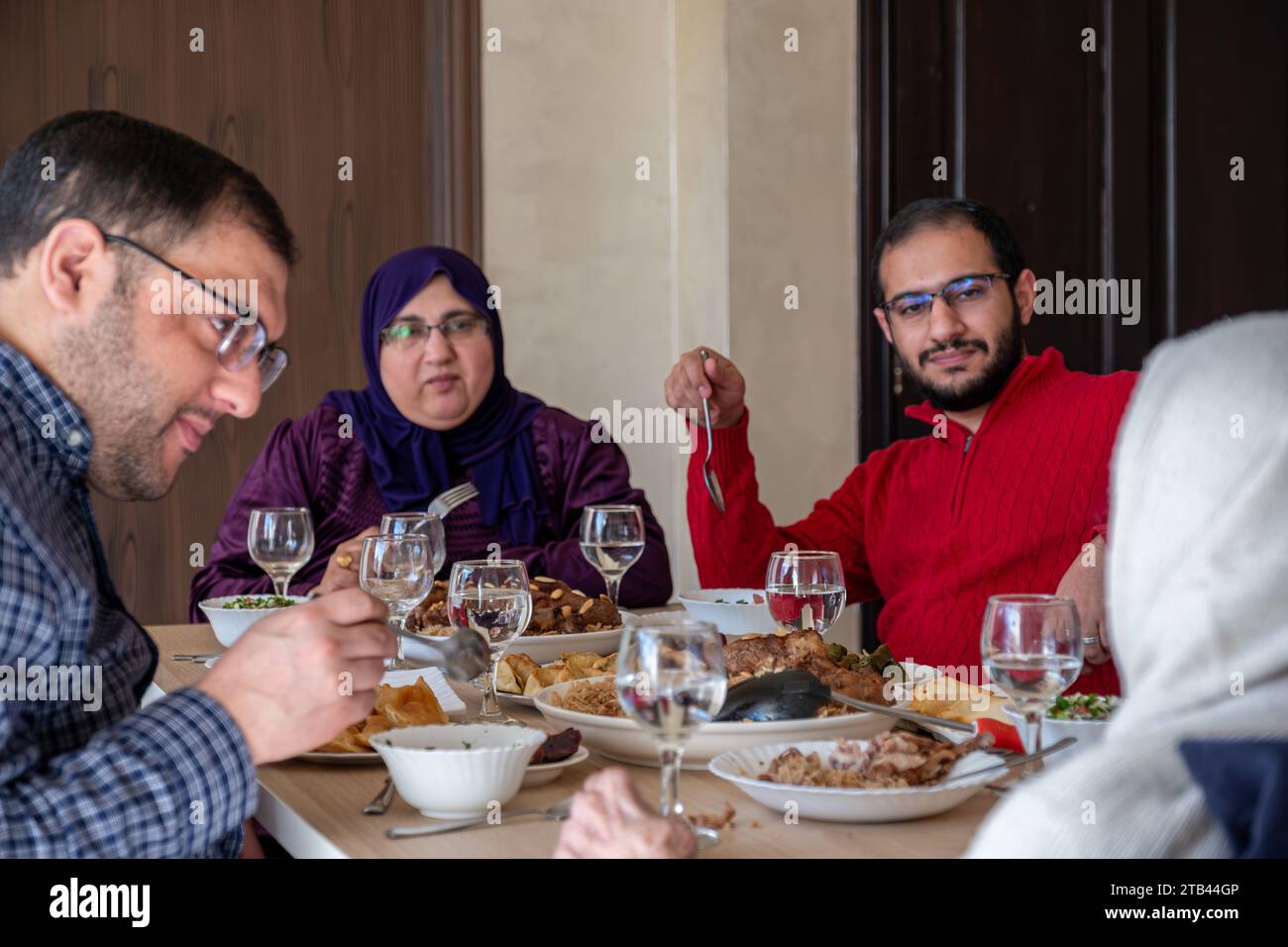 Familienessen mit Mitgliedern mehrerer Generationen im modernen Wohnzimmer Stockfoto