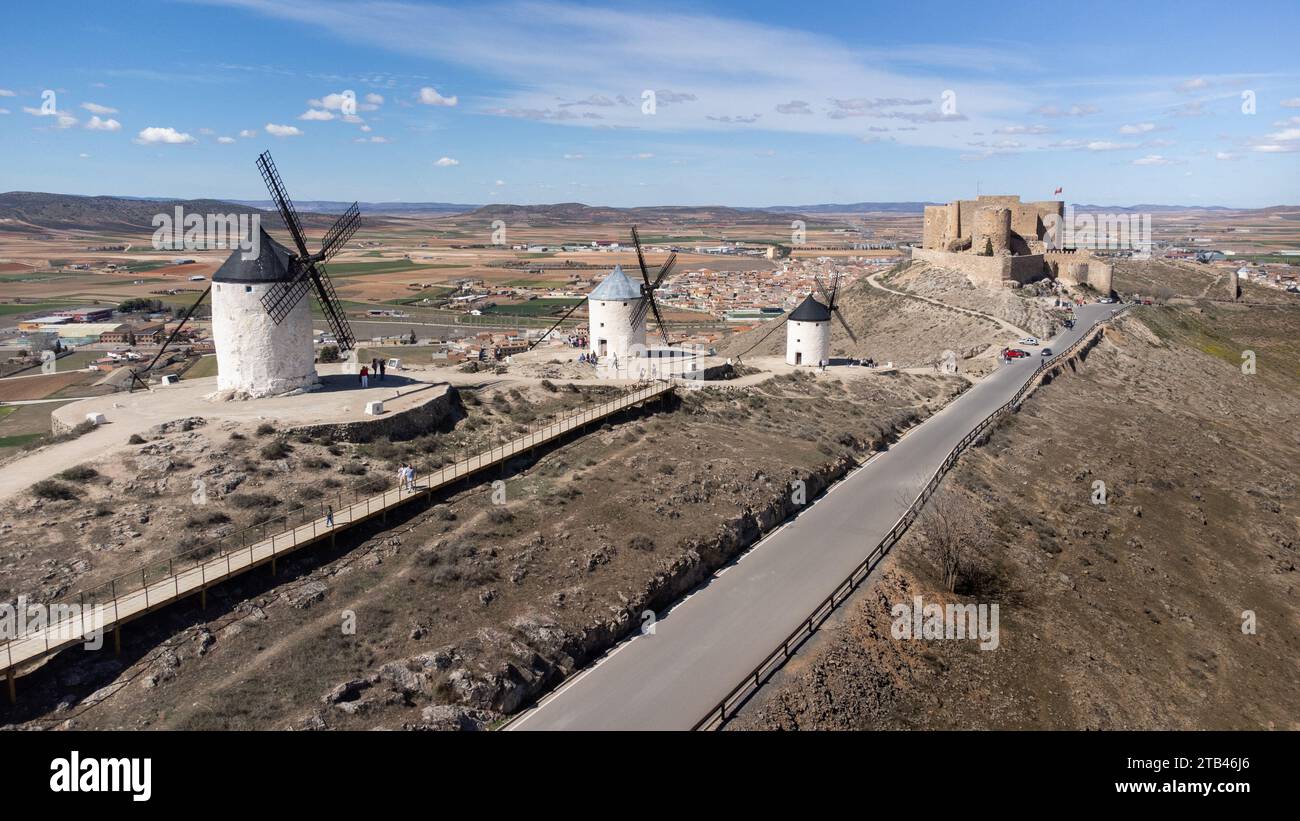 Alte Windmühlen, die dem Castillo de la Muela im Hintergrund entsprechen, in der Stadt Consuegra in der Provinz Toledo, Spanien. Typische Spanne Stockfoto