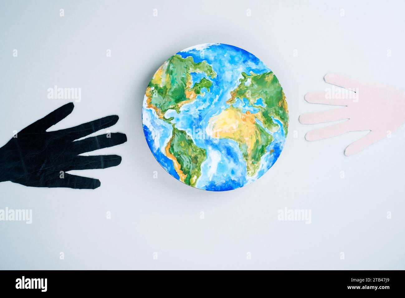 Multirassische Hände, schwarz und hell, erreichen Globen. Rettet den Planeten. Stockfoto