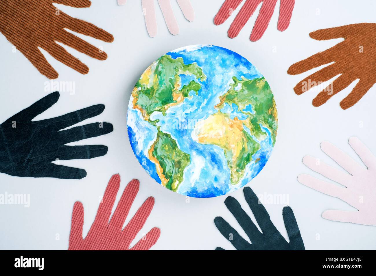 Internationaler Tag der Toleranz mit dem Planeten Erde und den acht Händen im Kreis. Isoliert auf grauem Hintergrund. Draufsicht Stockfoto
