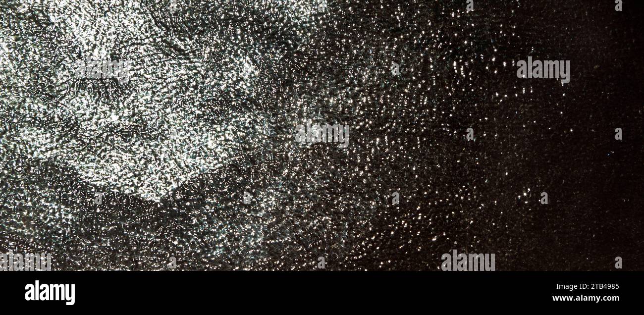 Lichtreflexionen auf einer Glasscheibe, abstrakter schwarz-weißer Hintergrund Stockfoto