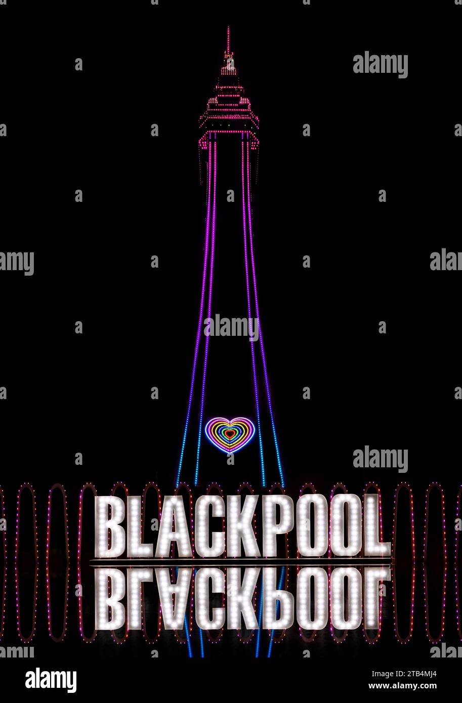 Blackpool, Lancashire, Großbritannien. November 2023. Blackpool Tower beleuchtet bei Nacht mit einem reflektierten Schild mit der Aufschrift Blackpool. Schwarzer Hintergrund Stockfoto