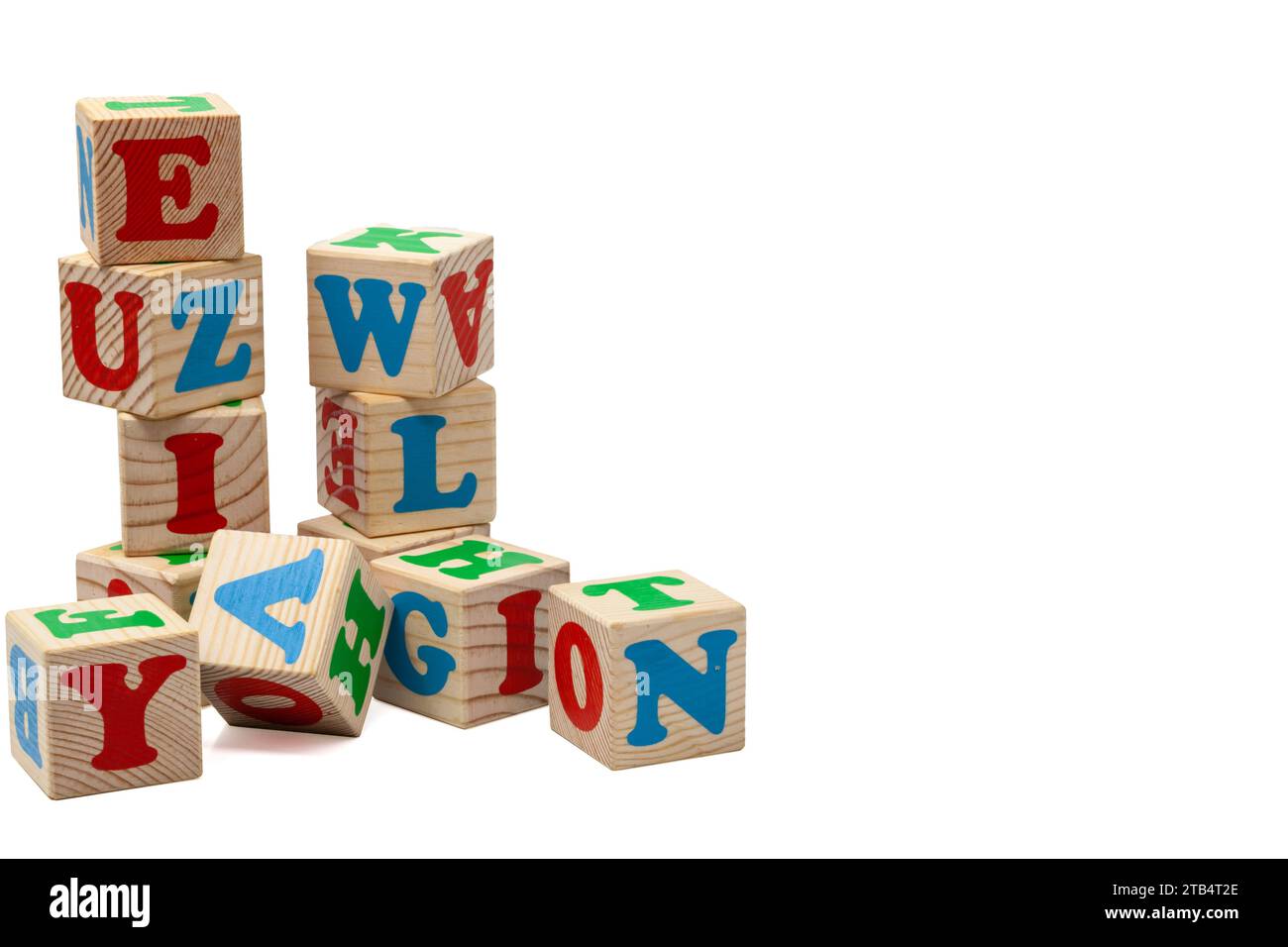 Hölzerne Spielwürfel für Kinder mit blauen, roten und grünen Buchstaben in Türmchenform stehen übereinander und liegen nebeneinander. Isolieren. Stockfoto