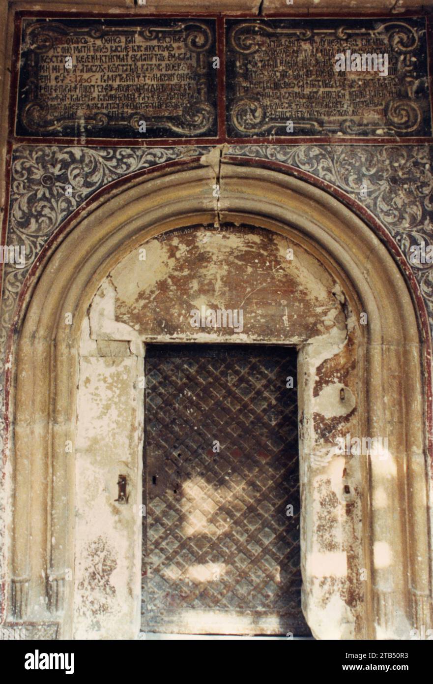 Vrancea County, Rumänien, ca. 1997. Kloster Mera, ein historisches Denkmal aus dem 17. Jahrhundert. Portal der Kirche mit der ursprünglichen Inschrift in zwei Sprachen (slawisch und griechisch). Stockfoto