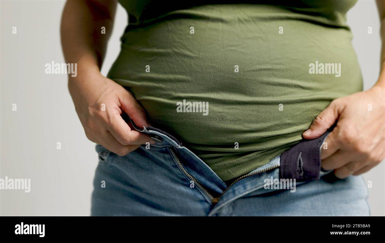 Fette Frau, die Hosen aufreißt, überschüssiges Bauchfett, ungesunder Lebensstil Stockfoto