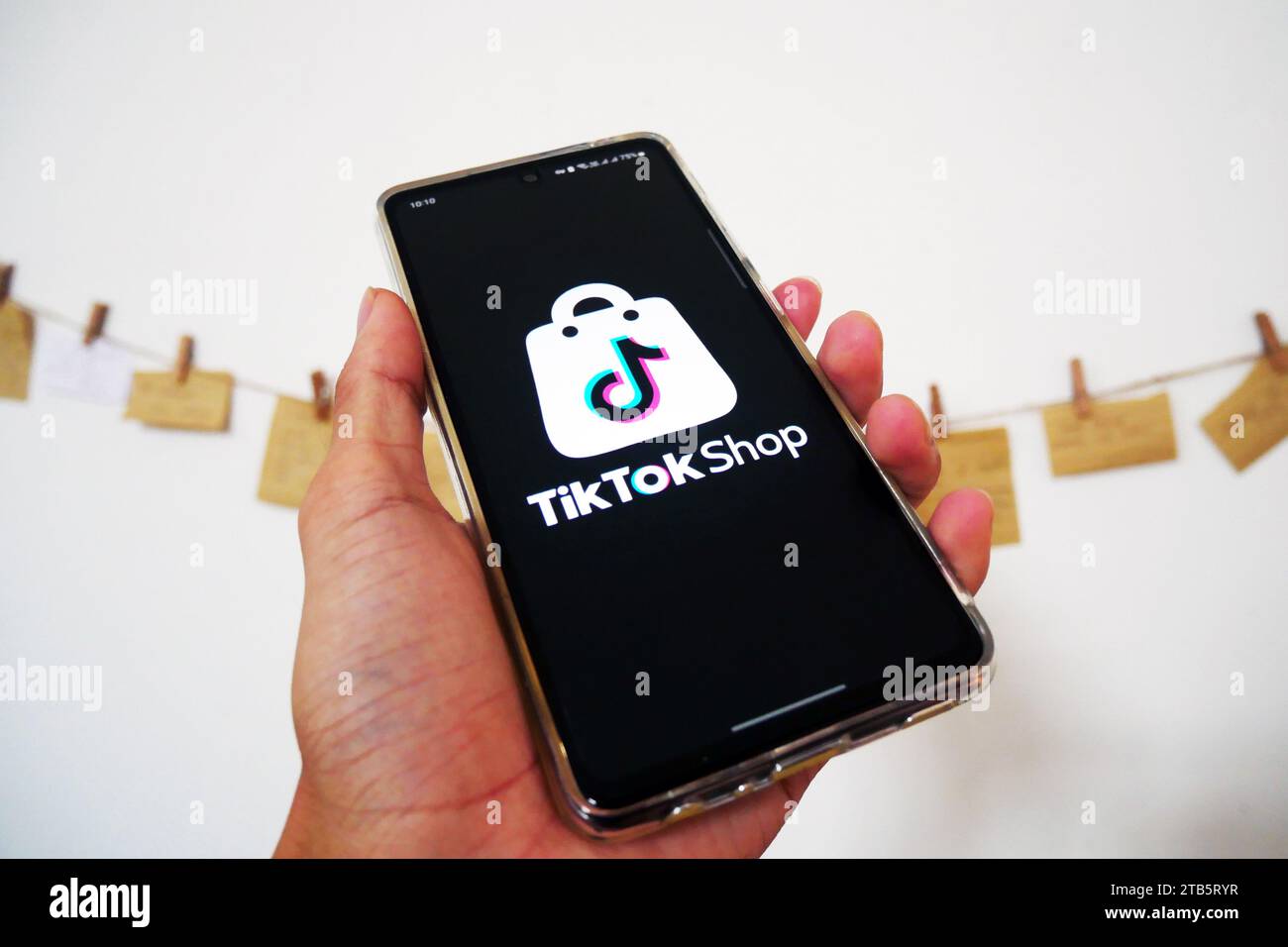 Hand hält ein Smartphone mit TikTok Shop. Weltweit beliebter Marktplatz. E-Commerce Social Media Commer Stockfoto