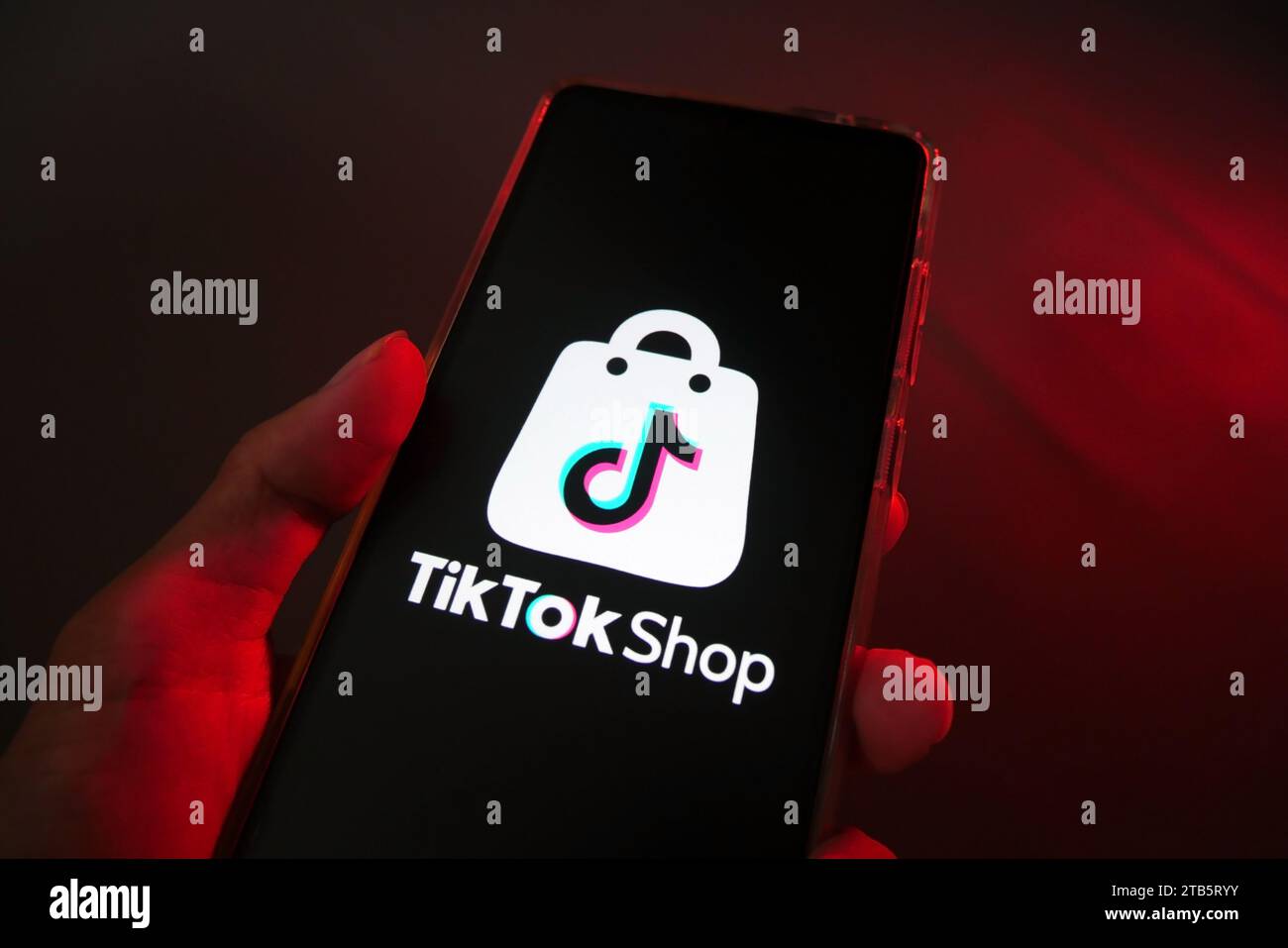 Hand hält ein Smartphone mit TikTok Shop. Weltweit beliebter Marktplatz. E-Commerce Social Media Commer Stockfoto