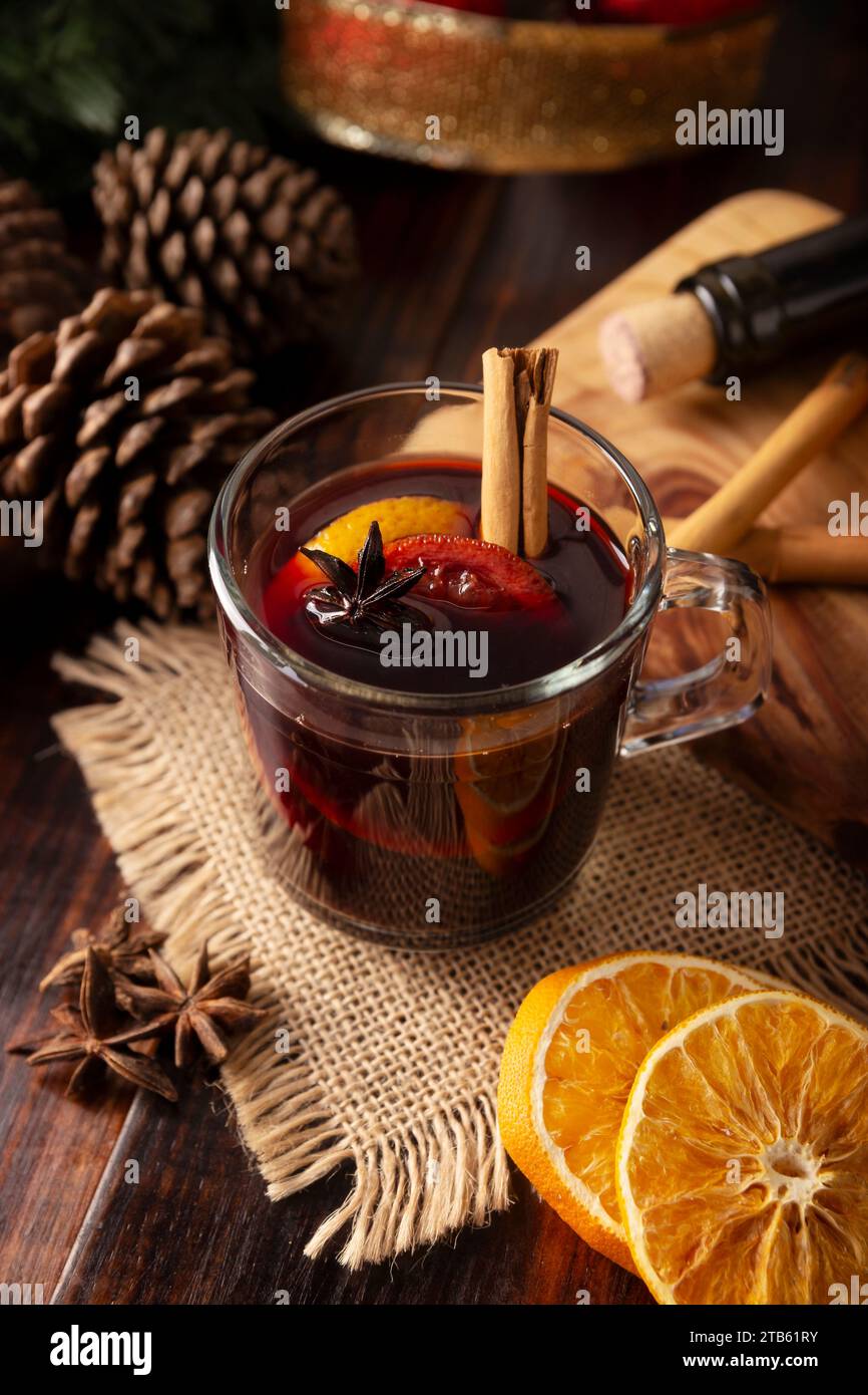 Gewürz- oder Weihnachtsglühwein mit Orange, Zimt, Sternanis, Nelke, Muskatnuss und anderen Zutaten auf einem rustikalen Holztisch. Traditionell heiß Stockfoto