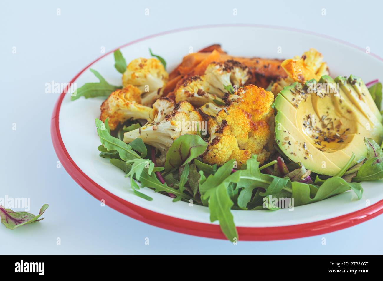 Warmer Wintersalat mit gebratenem Blumenkohl, Süßkartoffeln und Avocado, Nahaufnahme. Stockfoto
