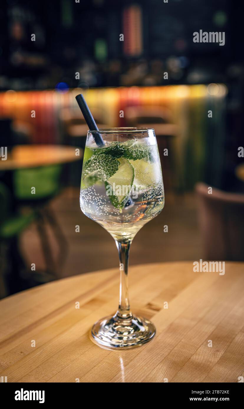 Alkoholgetränk, Gin Tonic Cocktail mit Limette serviert mit Trinkstroh Stockfoto