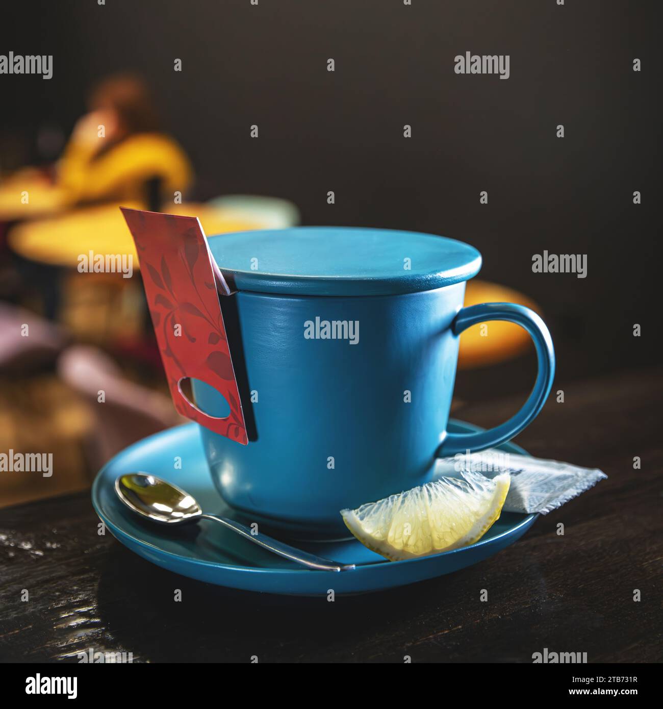 Blauer Keramikbecher mit Teebeutel, serviert mit Stockfoto