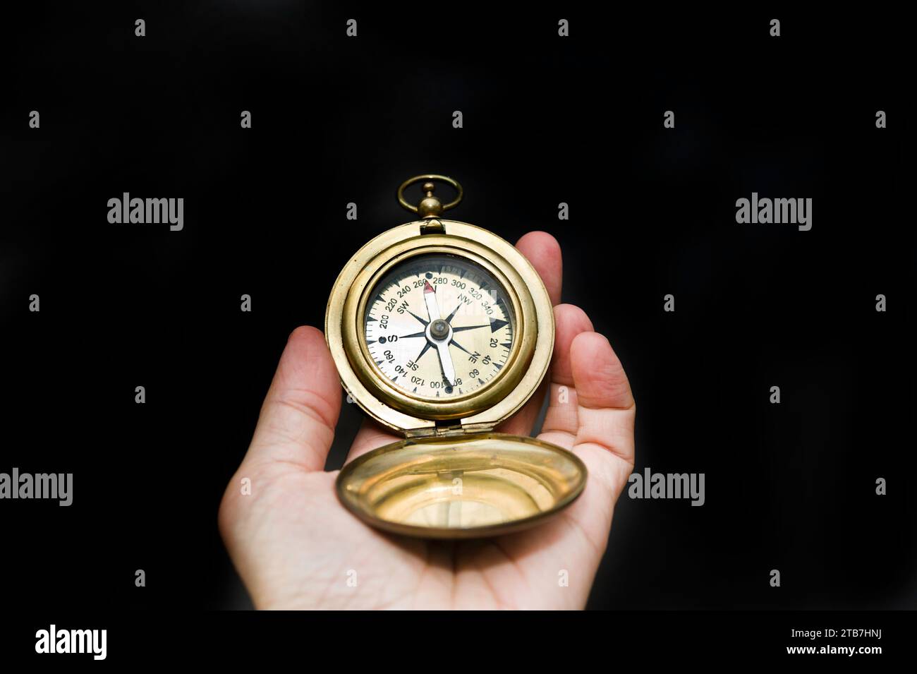 Hand hält einen Kompass für die Richtung, isoliert Stockfoto