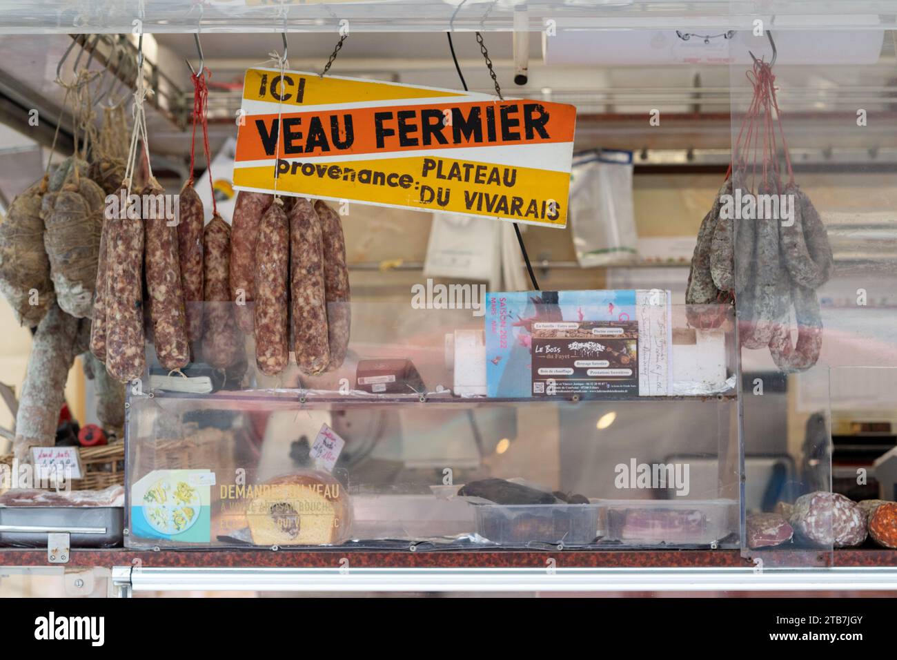 Annonay (Südostfrankreich): Atmosphäre an einem Wintermarkttag. Metzgerwagen, Würstchen und Schild Dies ist vom Vivarais-Plateau gezüchtetes Kalbfleisch Stockfoto