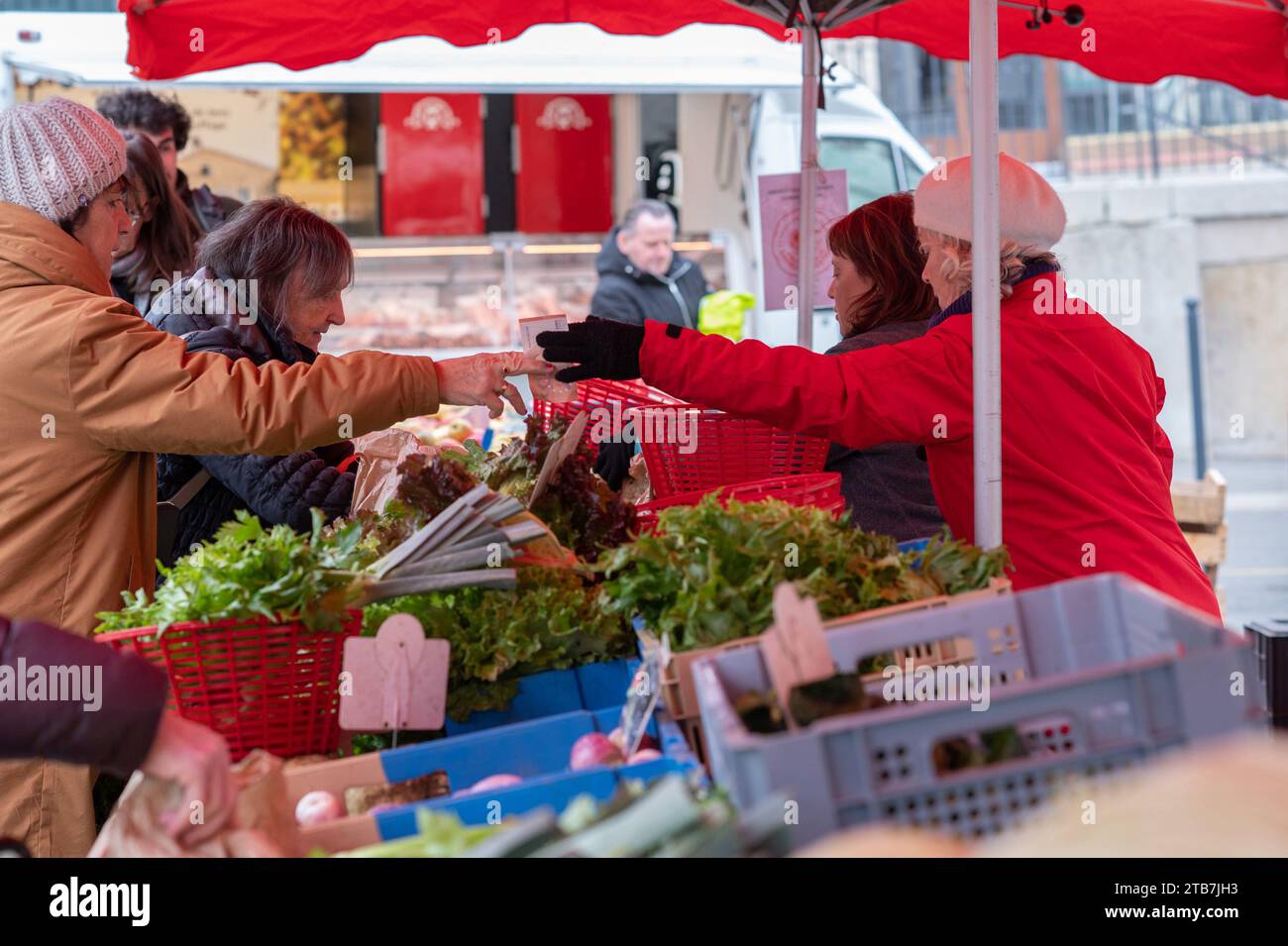 Annonay (Südostfrankreich): Atmosphäre an einem Wintermarkttag. Zahlung und Wechsel an einem Obst- und Gemüsestand Stockfoto