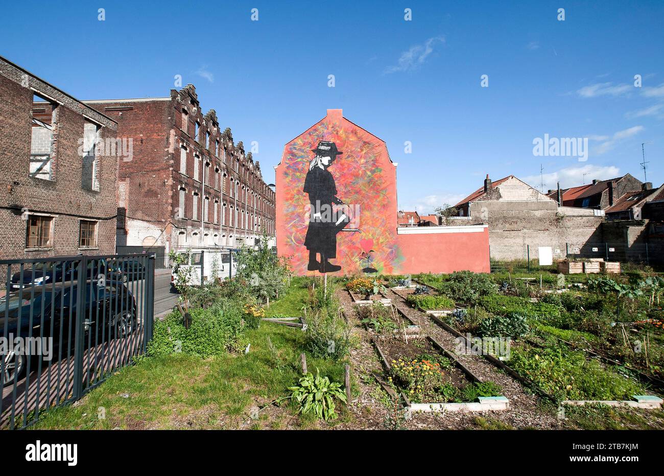 Roubaix (Nordfrankreich): Wandgemälde des Straßenkunstkünstlers Ted Nomad im Stadtteil Le Pile, kleines Mädchen mit einer Gießkanne und Gemeinschaftsgarten Stockfoto