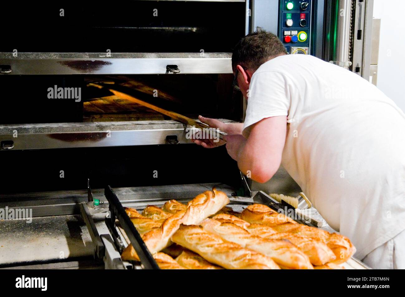 Bäckerei: Brotbackerei im Bäckerhaus. Abbildung einer Bäckerei, die mit einem Pelletbrotbackofen betrieben wird, Auswirkungen steigender Strompreise. Frisch Stockfoto