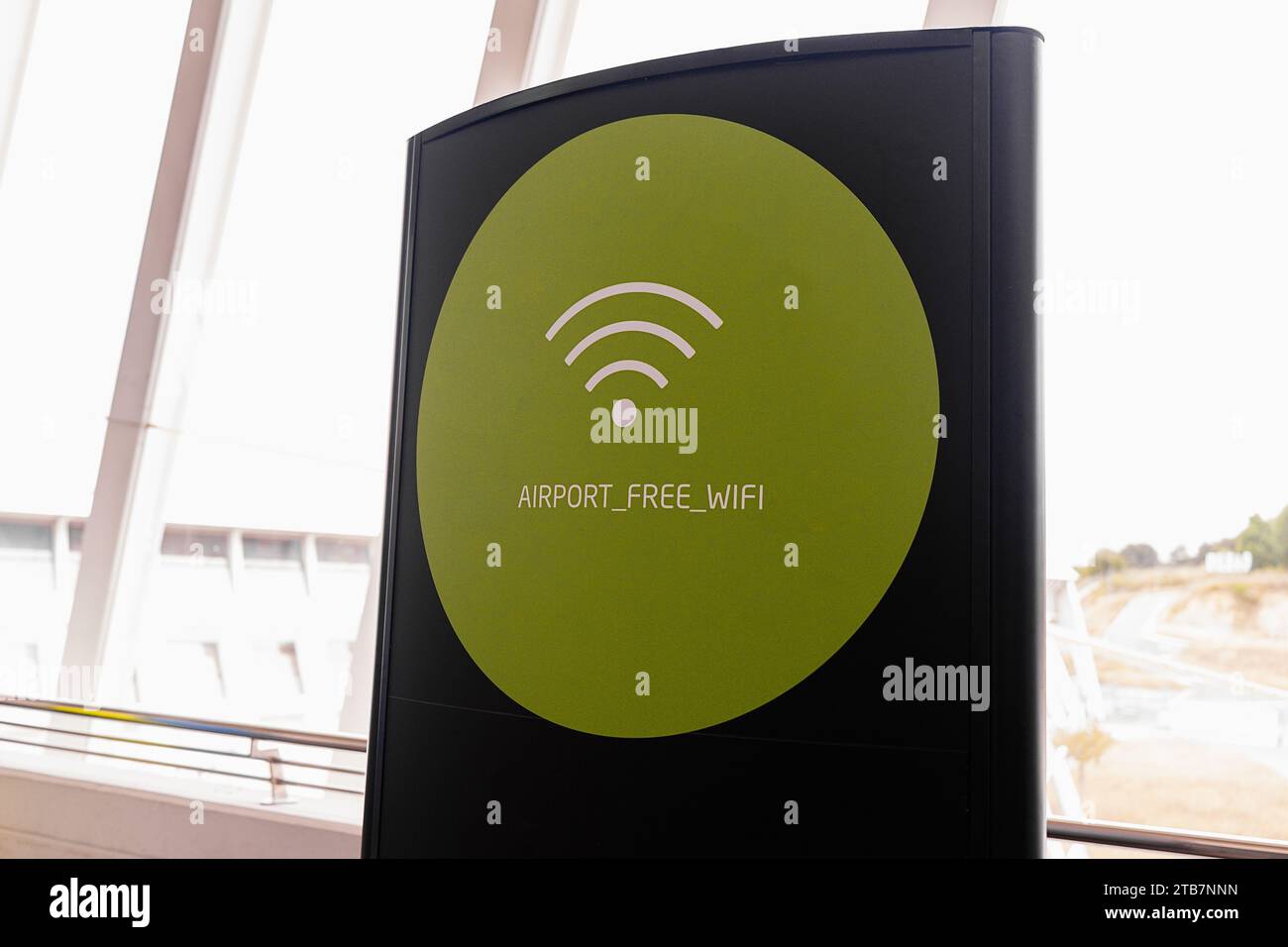 Grüner Kreis mit kostenlosem WIFI-Zugang auf schwarzem Schild vor hellen Fenstern im modernen Terminal Stockfoto