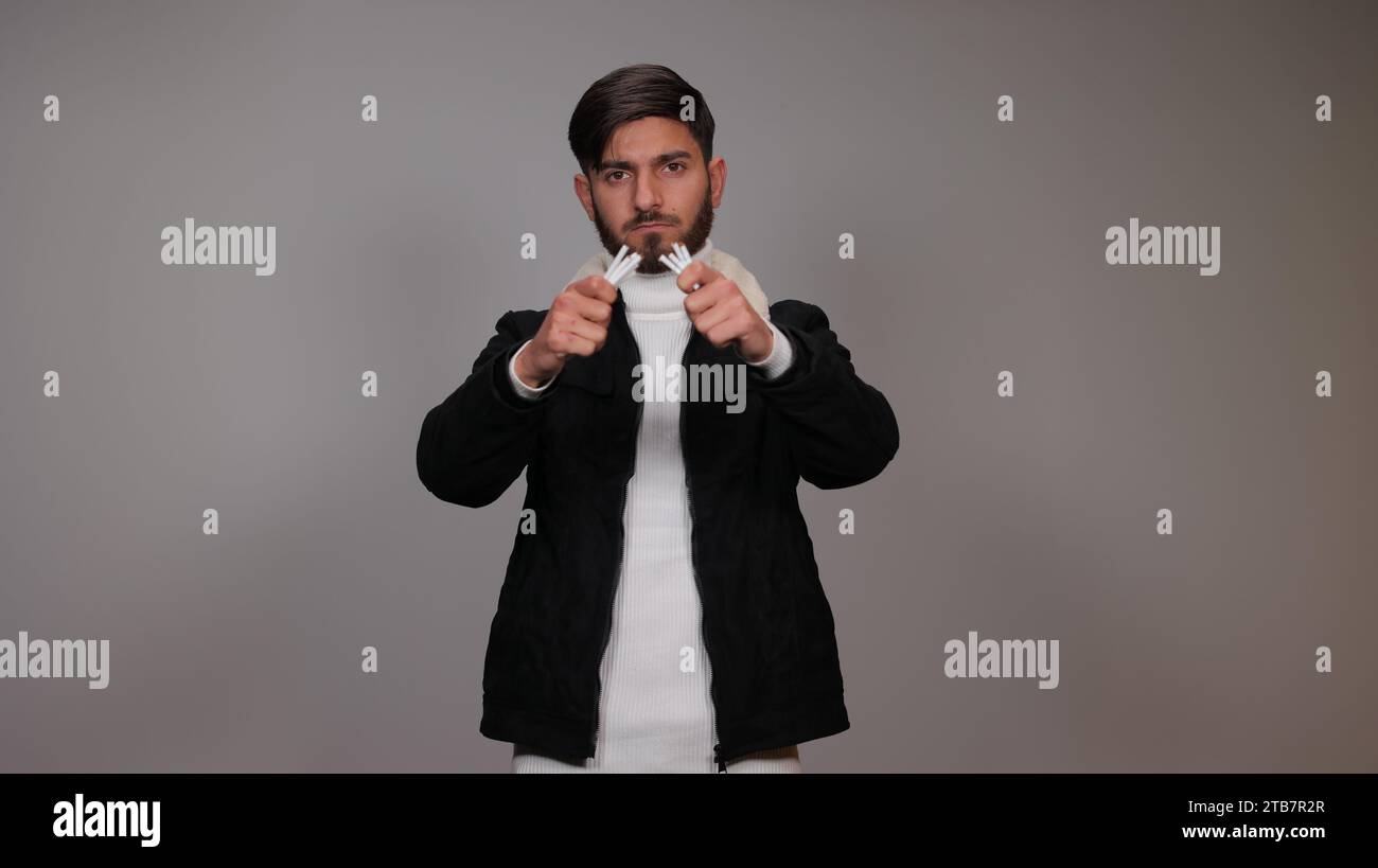 Ein junger Mann, der Zigaretten bricht und das Konzept des Rauchens betont | Rauchen aufhören Stockfoto