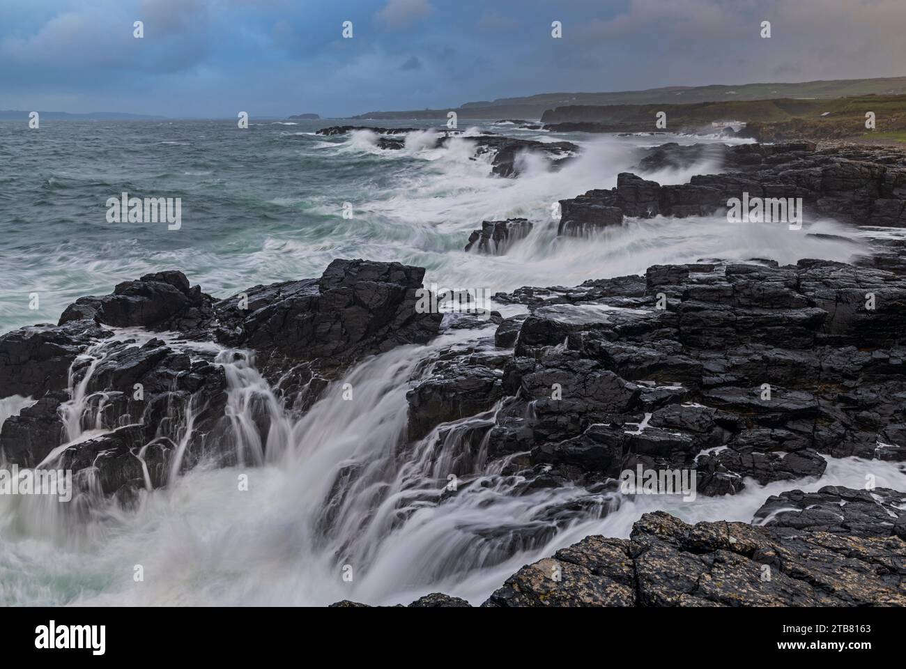 Wellen brechen über die felsige Küste von Dunseverick an der Causeway Coast in Nordirland, Großbritannien. Herbst (November) 2022. Stockfoto