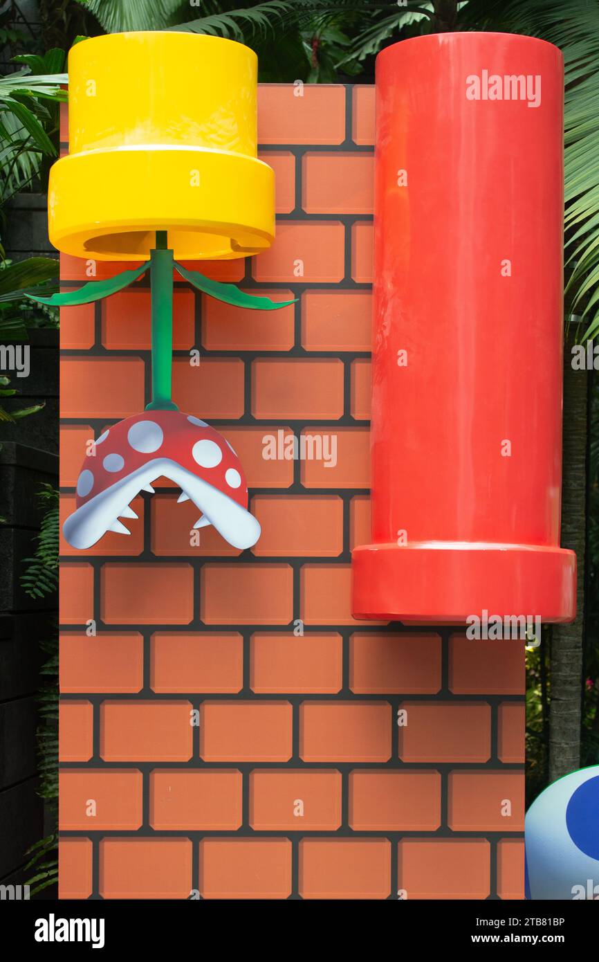 Echte Live-Darstellung der Piranha-Pflanze und der roten Pfeife, die im Super Mario Nintendo-Spiel zu sehen sind. Singapur. Stockfoto