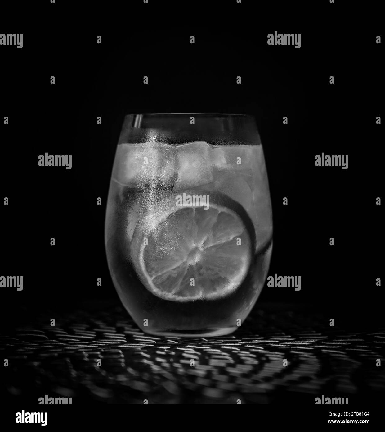Gin-Tonic-Cocktail in Schwarz-weiß mit Eis und Zitrone Stockfoto