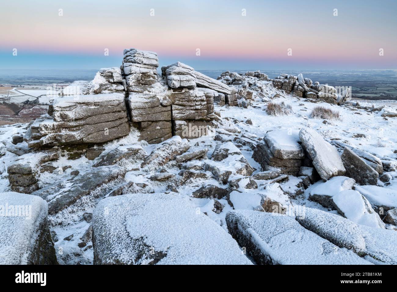 Schnee- und eisbedeckte Moorlandschaft bei Sonnenaufgang am Belstone Tor im Dartmoor-Nationalpark, Devon, England. Winter (Dezember) 2022. Stockfoto