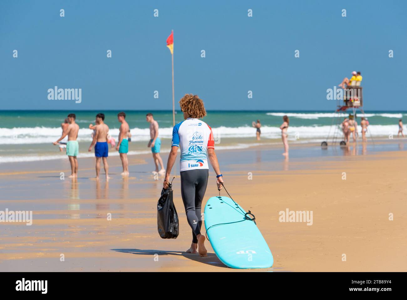 Biscarosse-(Südwestfrankreich): Biscarosse-Plage, Strand und Surfplatz. Französischer Surflehrer auf dem Sand. Im Hintergrund, Schwimmer Stockfoto