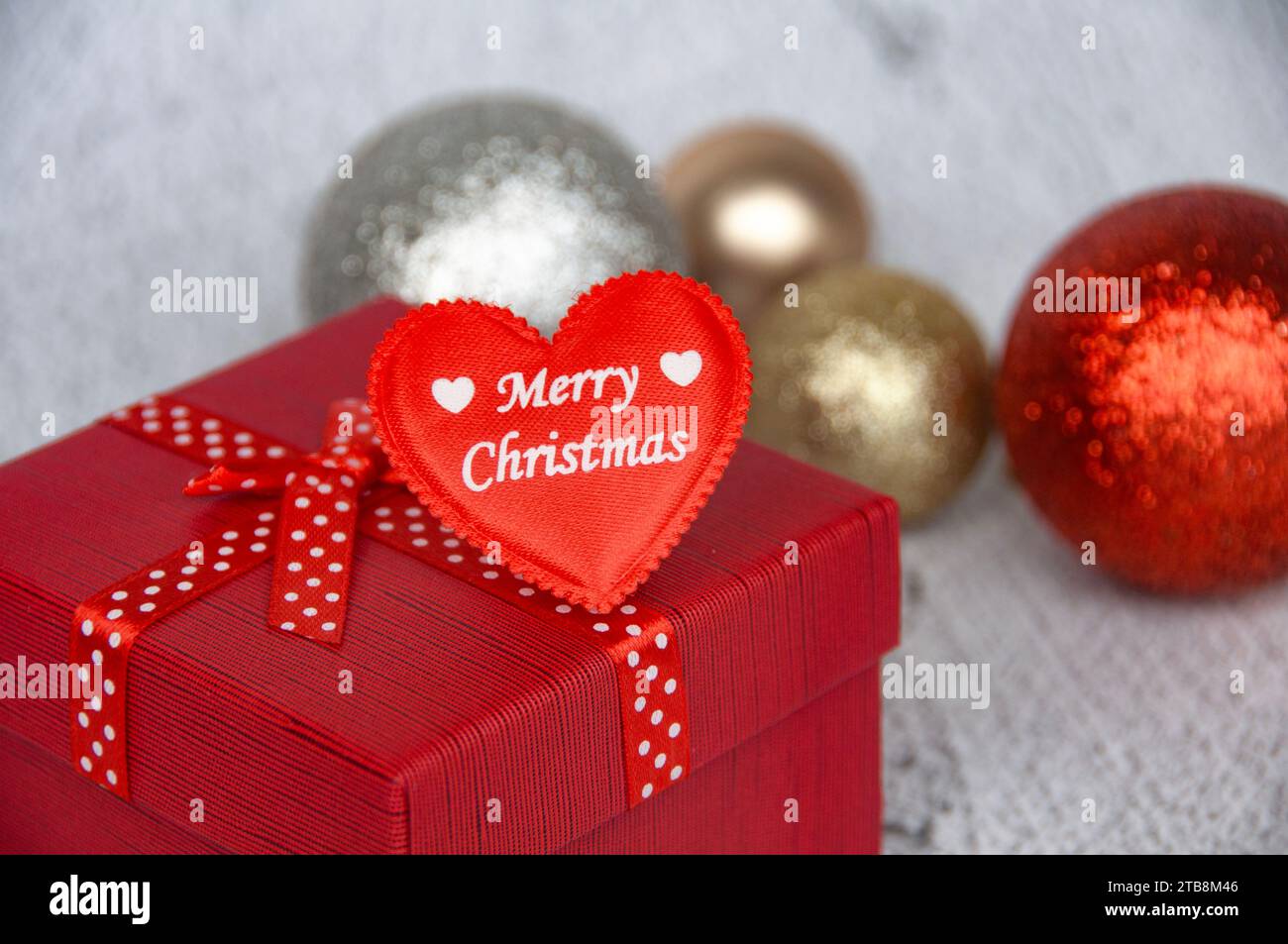 Fröhlicher Weihnachtstext in Herzform mit Weihnachtsgeschenken und -Dekoration. Season Greetings. Stockfoto