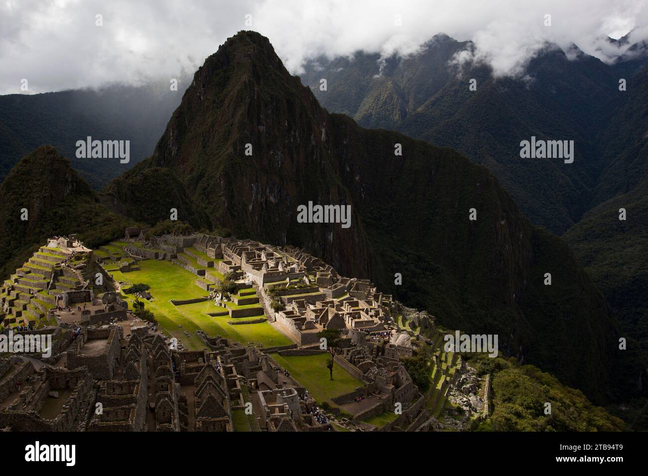 Das Sonnenlicht trifft Machu Picchu durch einen Bruch in den Wolken; Peru Stockfoto