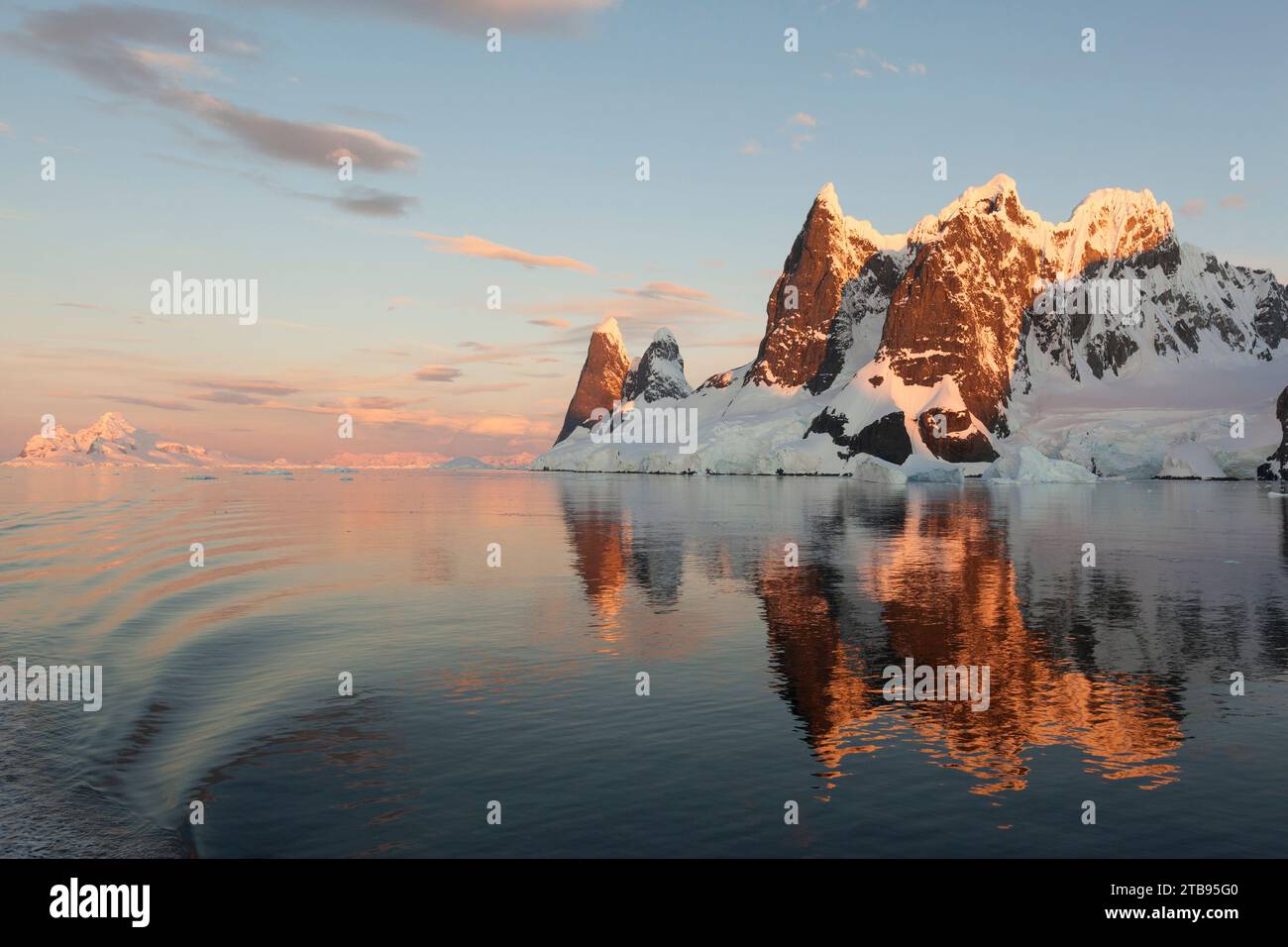 Reflexionen von Klippen und Bergen im Lemaire-Kanal bei Sonnenuntergang; Antarktis Stockfoto