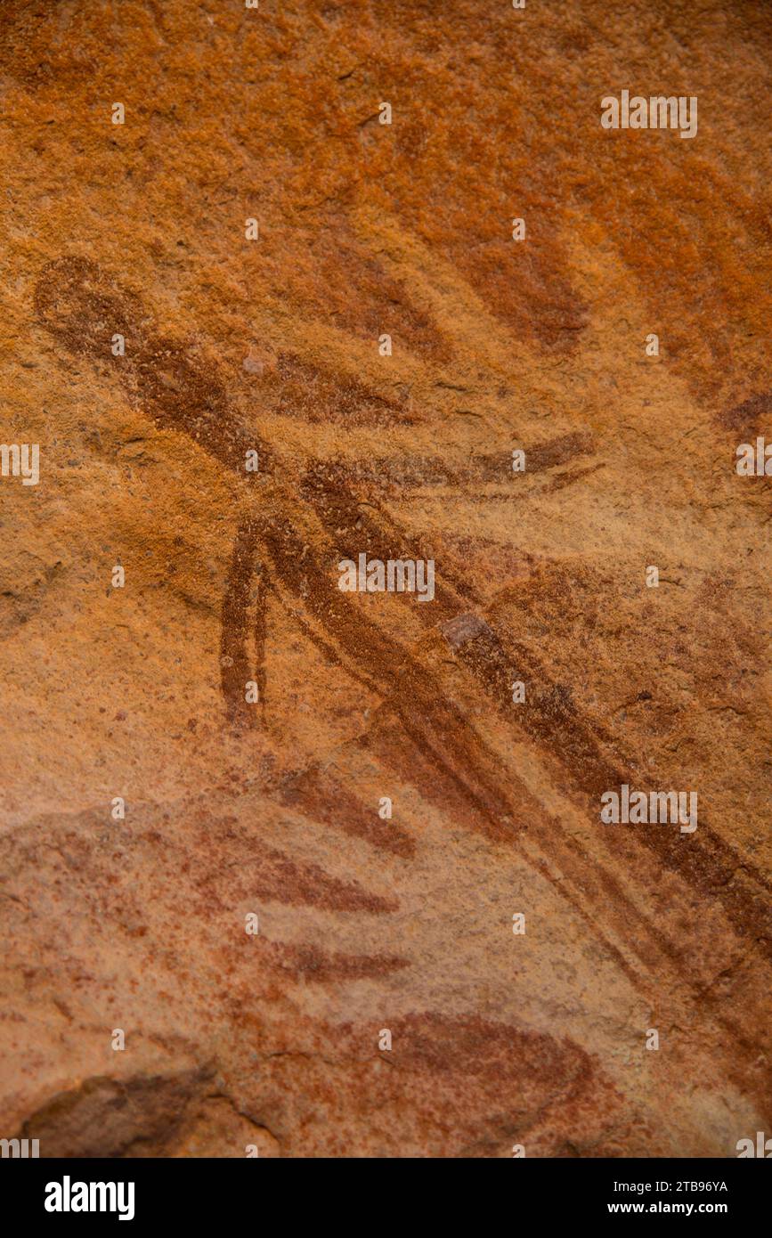 Eine stilisierte menschliche Figur überlagert sich mit zwei rechts schablonierten Bildern, die Teil der Bradshaw Rock Paintings-Sammlung prähistorischer australischer Kunst sind Stockfoto
