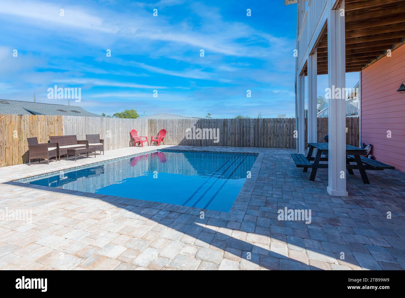 Traumhafte Nachmittage am eingebauten Pool im Garten, umgeben von stilvollen Möbeln, unter dem azurblauen Himmel mit flauschigen weißen Wolken – ein pe Stockfoto