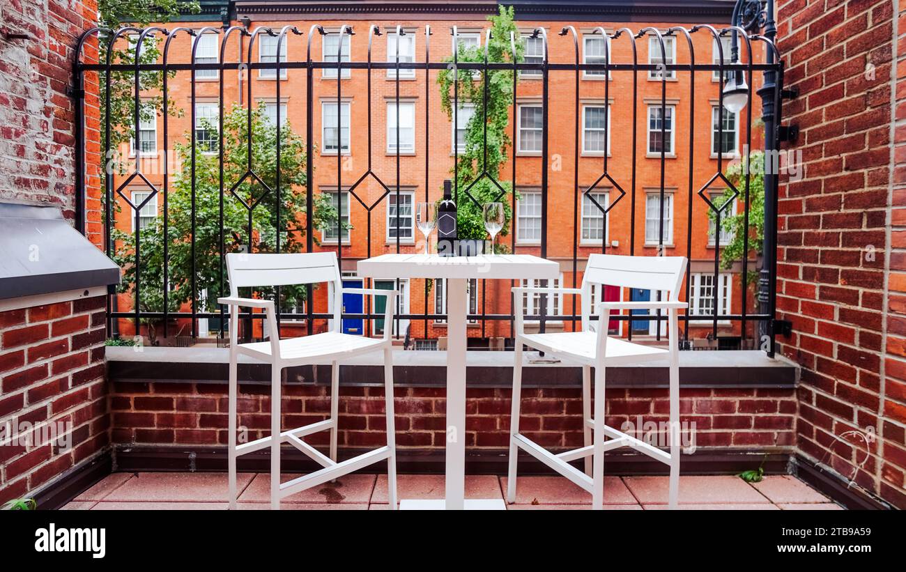 Tisch mit Wein und zwei Gläsern auf dem Balkon mit Stühlen für zwei Personen Stockfoto