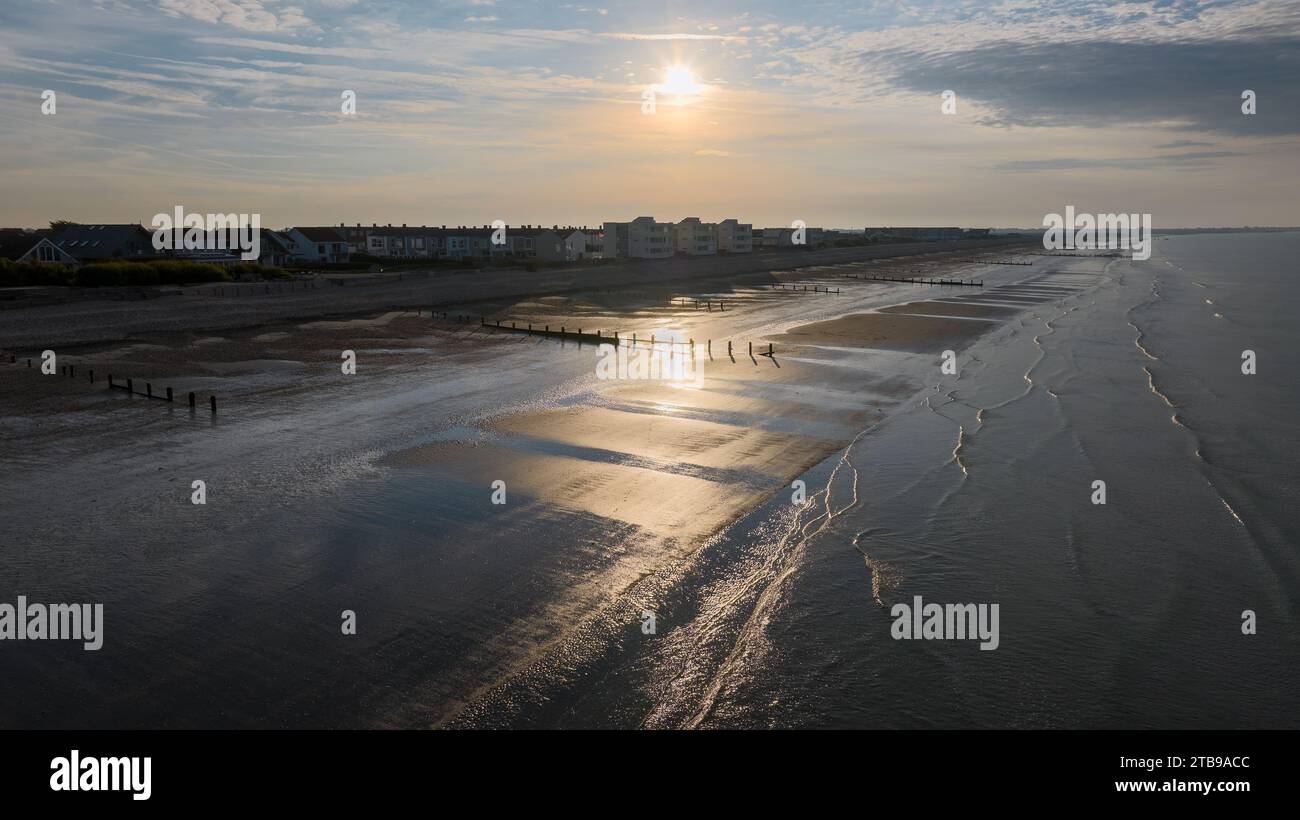 Bracklesham Bay an einem sonnigen Sommermorgen. Erhöhter Blick auf den tollen Strand und die Küstenlandschaft. Sträucher schützen den Strand vor Erosion. Stockfoto