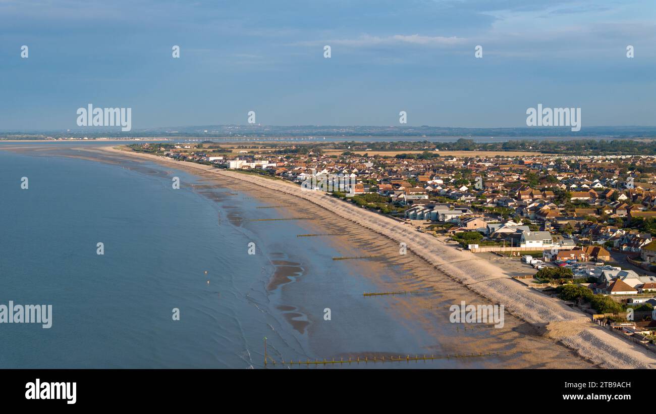 Bracklesham Bay an einem sonnigen Sommermorgen. Erhöhter Blick auf den tollen Strand und die Küstenlandschaft. Sträucher schützen den Strand vor Erosion. Stockfoto