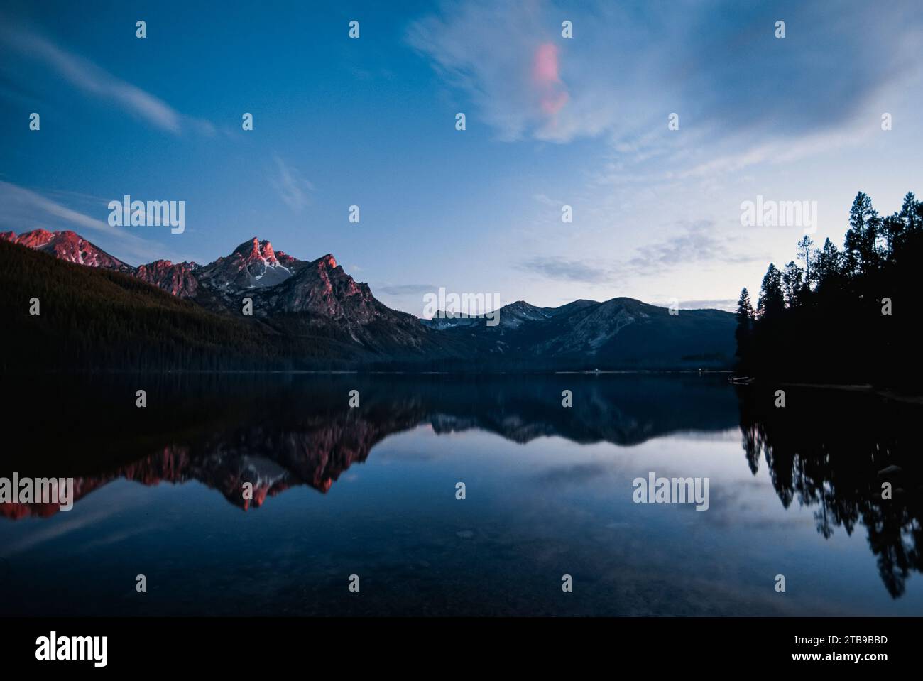 Blick auf die Sawtooth Range in der Dämmerung, reflektiert auf dem Sawtooth Lake; Idaho, Vereinigte Staaten von Amerika Stockfoto